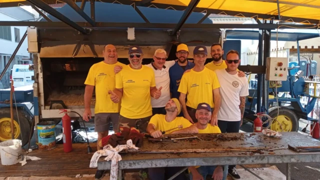 Volontari di Quelli del Camino davanti al grande girarrosto